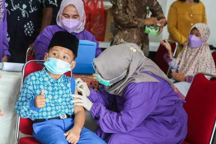 Tenaga medis saat menyuntik anak laki-laki vaksinasi