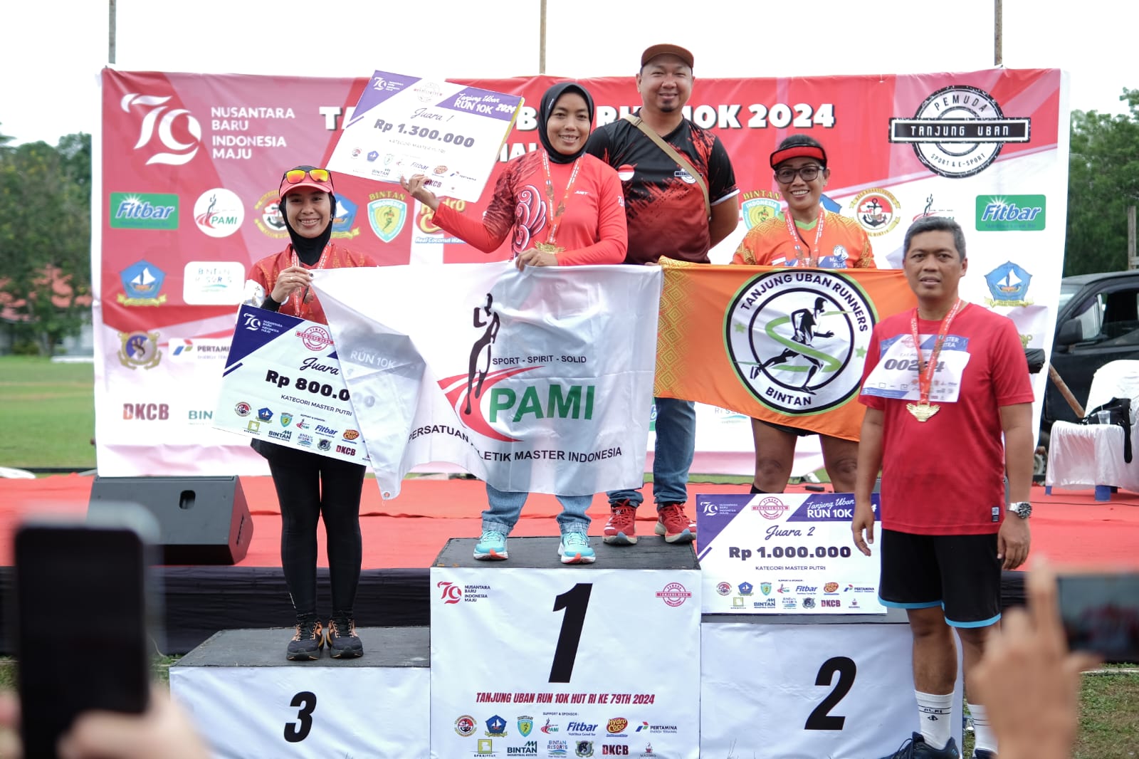 Ketua Pelaksana Event Tanjunguban Run 10K Alvin Stevanus Agape bersama Komandan Lanal Bintan Letkol Laut (P) Eko Agus Susanto, S.E., M.M. berfoto bersama dengan juara Kategori Master Putri di Event Tanjunguban Run 10K, Minggu (25/8/2024) foto istimewa